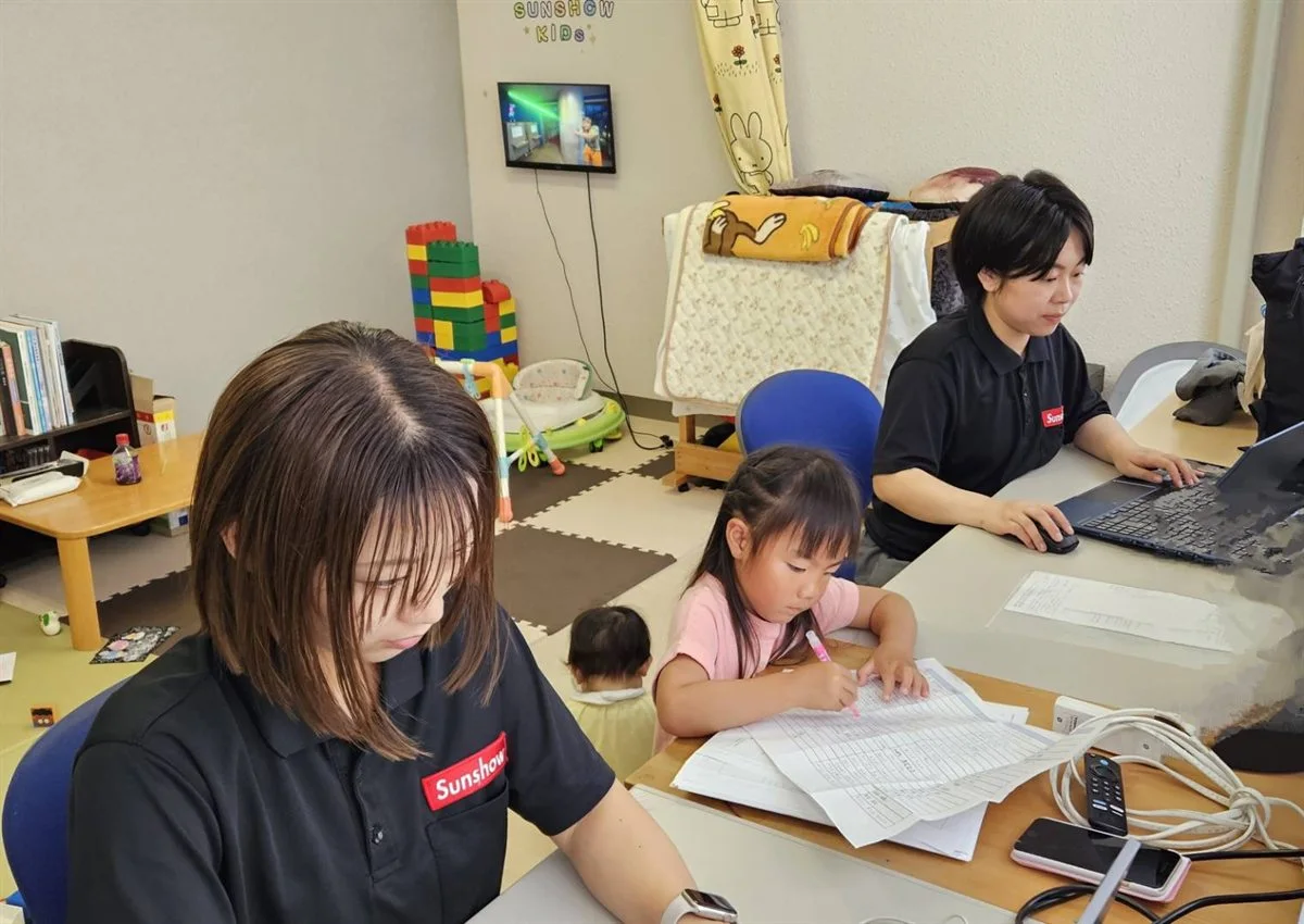 SUNSHOW KIDSの部屋で子どものそばで仕事をする社員たち